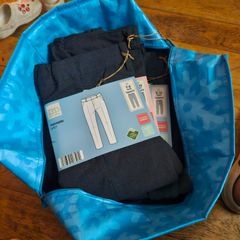 Bag of school pinafores and trousers.