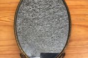 Brass framed ornate oval mirror