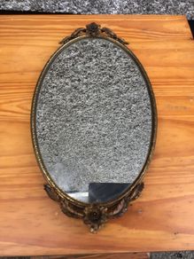 Brass framed ornate oval mirror