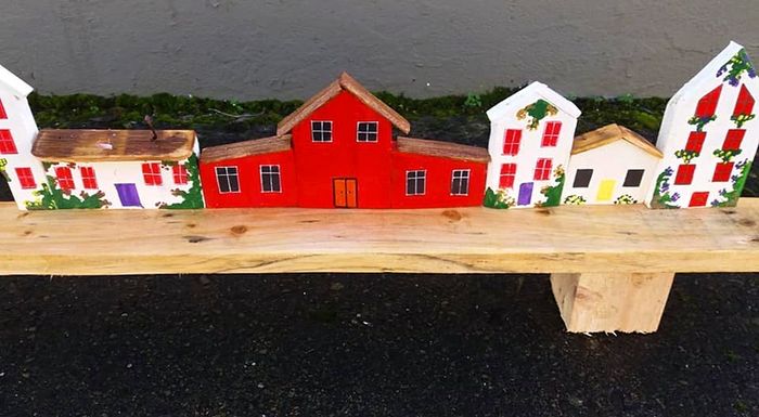rustic wooden floating shelf display featuring a hand-painted village scene