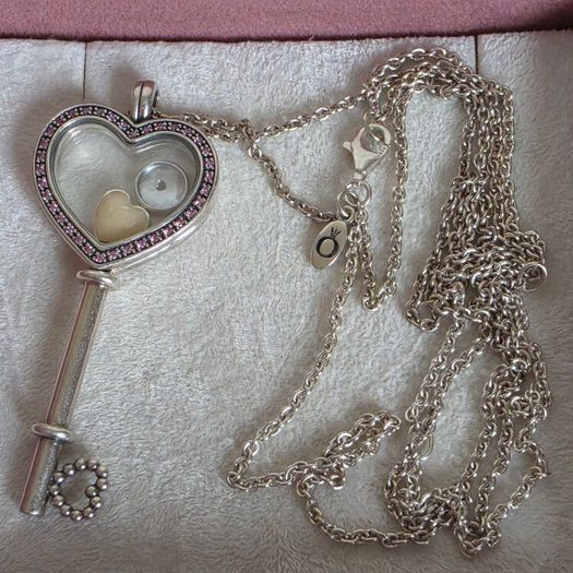 Pandora sterling silver key necklace with a heart,shaped floating locket and pink sparkling stones. Includes the two petite charms
