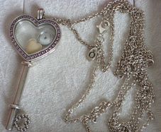 Pandora sterling silver key necklace with a heart,shaped floating locket and pink sparkling stones. Includes the two petite charms