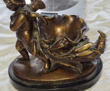 Bronzed Winged Cherub putto open seashell or leaf-shaped vessel with a scorpion like tail.