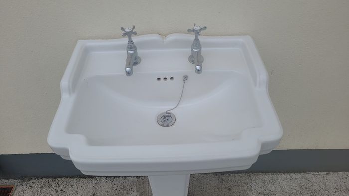 Bathroom sink with pedestal, taps and trap