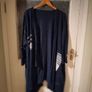 long-sleeved navy garment is an oversized graphic Jacket cardigan. Image 7