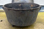 Antique cast iron tri-legged dutch oven and lid.