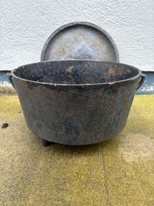 Antique cast iron tri-legged dutch oven and lid.