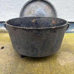 Antique cast iron tri-legged dutch oven and lid.