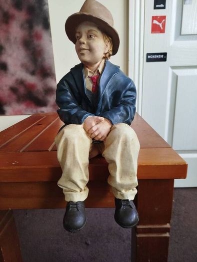 Resin sculpture of a seated boy
