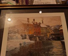 Framed print of  Snow-Covered Buildings by a River by Fritz Thaulow (1847 - 1906).