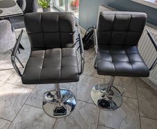 Pair of grey faux leather bar stools with chrome base
