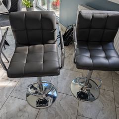Pair of grey faux leather bar stools with chrome base