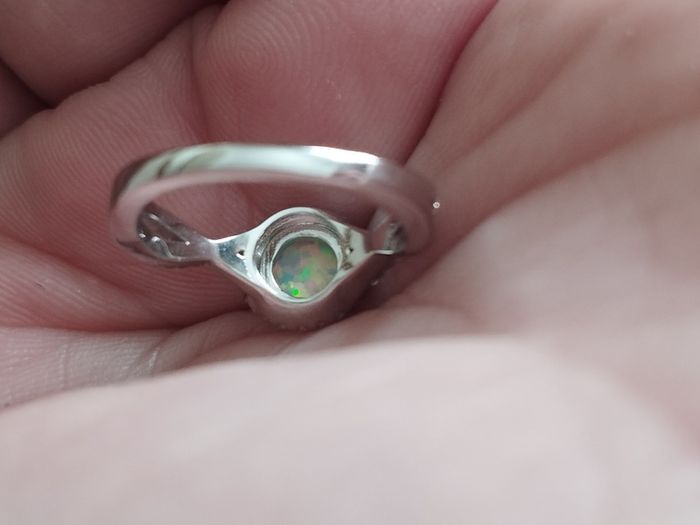 A beautiful 925 silver ring with a white lab opal surrounded by shining cubic zirconia.