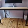 Modern desk with light wood top and black metal frame Image 2