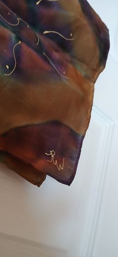 Hand painted, 100% silk scarf featuring a hand-rolled hem and custom metallic gutta detailing.