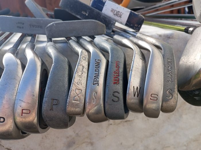 A selection of golf clubs and bags. All right handed clubs.