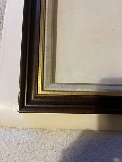 frame A rich dark-wood and gilt picture frame featuring a textured fabric mat liner.