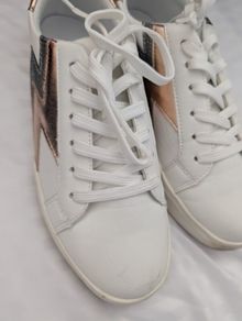 Runners in white with gold and grey lightning bolt on side
