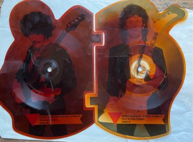 Rare and collectible Gary Moore and Phil Lynott special 2 in 1 shaped picture disc. Out in the fields and military man. Bought this new back in the day. Records were never played but picture disc discoloured over time as all versions did. Still highly col