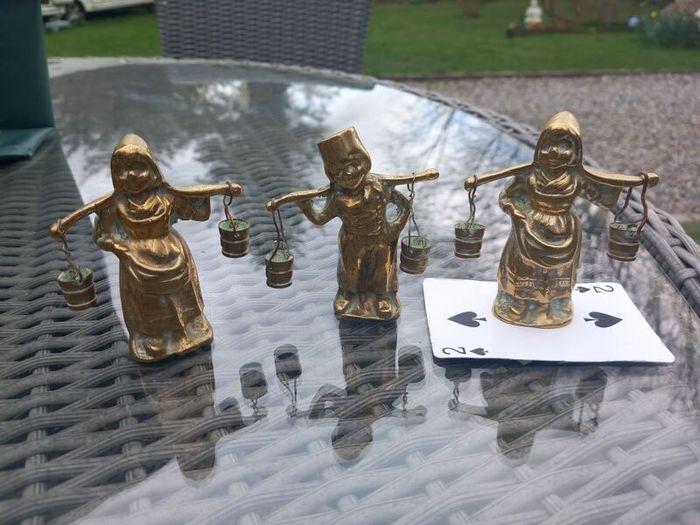 3 brass figures with water buckets, D18 post 7e