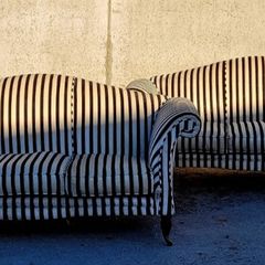 Vintage pair of camelback sofas