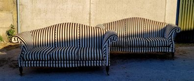 Vintage pair of camelback sofas