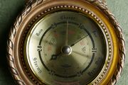 Vintage barometer with silvered dial mounted in an ornate gilt frame.
