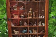 vintage glass display wall cabinet with Wade collection figurines