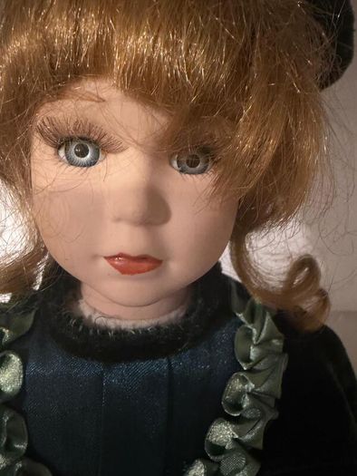 Vintage porcelain doll in green velvet dress