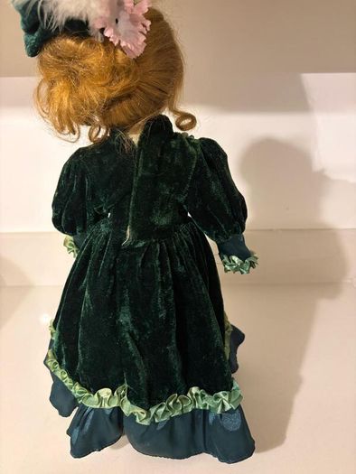 Vintage porcelain doll in green velvet dress
