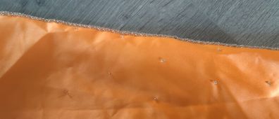 Solid orange satin look piece of fabric with beads