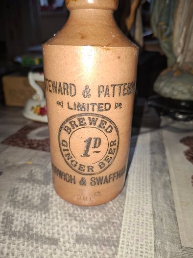 Antique stoneware ginger beer bottle from the Norfolk brewer Steward & Patteson Limited, featuring a "1D" (one penny) price mark