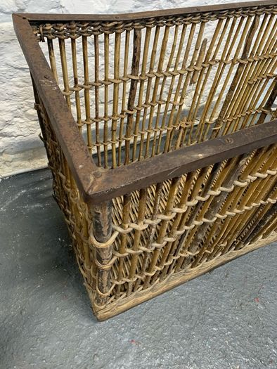 Large Victorian cane and metal laundry basket on wheels.
