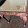 Vintage Queen Anne-style wooden coffee table featuring cabriole legs, a glass top protecting an inset leather surface with gold tooling Image 3