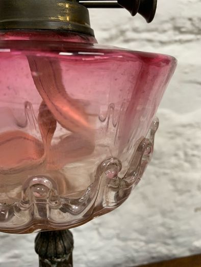Early Edwardian oil lamp with cast metal base.