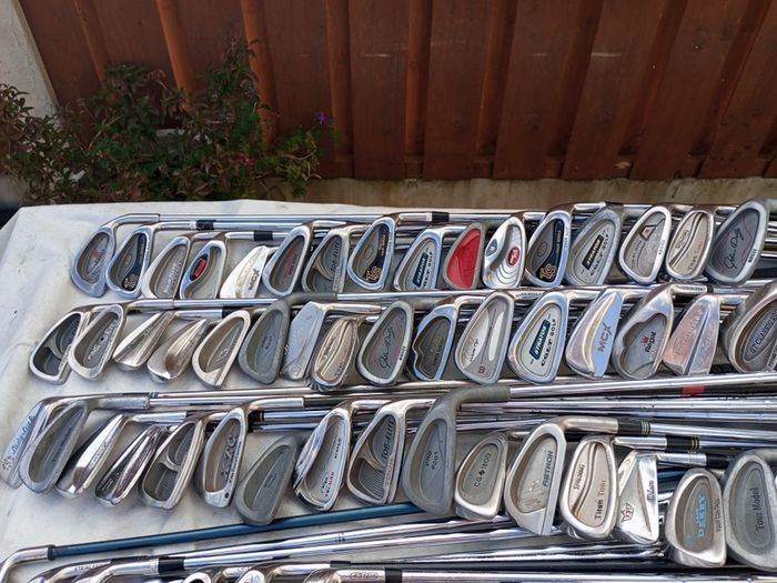 A selection of golf clubs and bags. All right handed clubs.