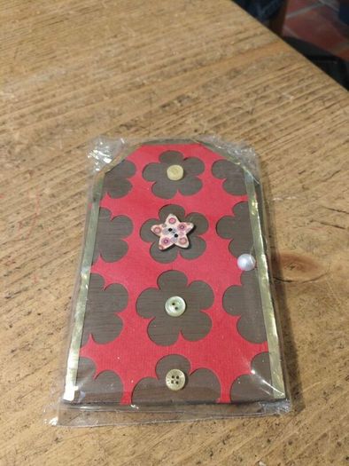 handcrafted wooden  Fairy door with red cardstock, brown flower cutouts, and decorative buttons.  various buttons acting as handles or embellishments.