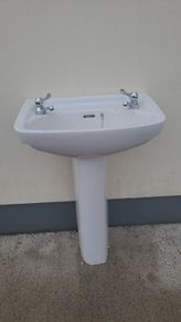 Bathroom sink with pedestal, taps and trap
