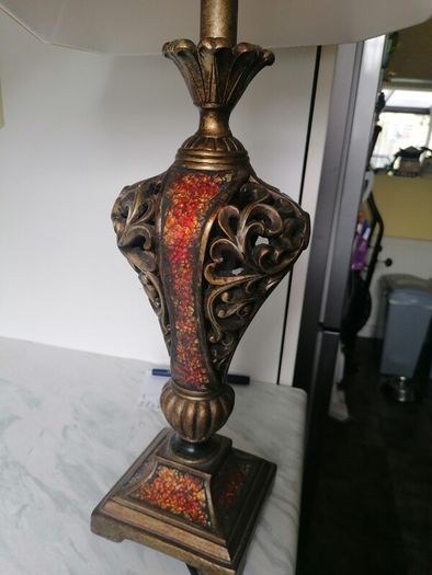 Vintage Tuscan style table lamp with gold-finish resin body with intricate scrollwork and reddish-orange mosaic crackle accents