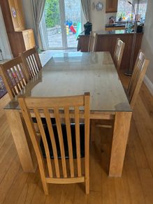 solid oak table with glass on top and 8 chairs