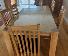 solid oak table with glass on top and 8 chairs