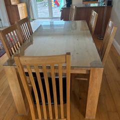 solid oak table with glass on top and 8 chairs