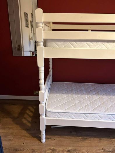 White wooden bunk beds with mattresses