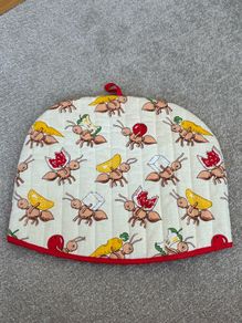 quilted cotton tea cosy featuring a playful ant and picnic food print