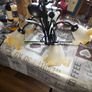 Vintage Style Chandelier with 5 Corolla Shaped shades in frosted Glass Set against a Central Foliage Structure made of black metal Image 2