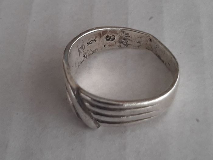 Silver ring clasping hands