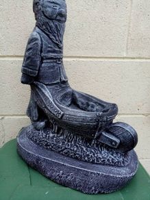Man holding a wheelbarrow garden gnome planter