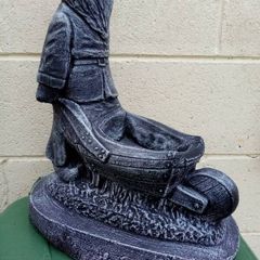 Man holding a wheelbarrow garden gnome planter