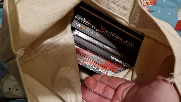 bag of U2 promo CD singles, CD albums and DVD sets