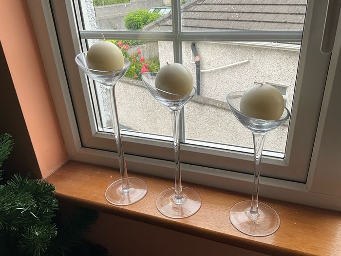 Set of 3 clear glass stemmed candle holders with ivory candles